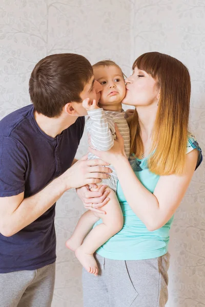 Junge glückliche Eltern küssen kleinen Jungen — Stockfoto