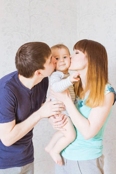 Junge glückliche Eltern küssen kleinen Jungen — Stockfoto