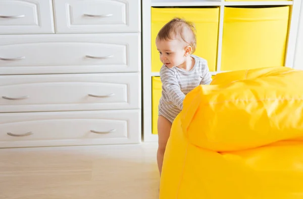 Niedlich glücklich lachende Baby-Junge spielt auf weißen Schlafzimmer. — Stockfoto