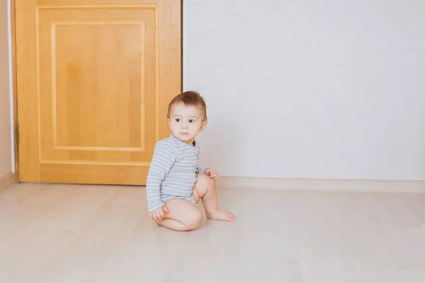 Söt baby pojke småbarn sitter på golvet i sovrummet — Stockfoto