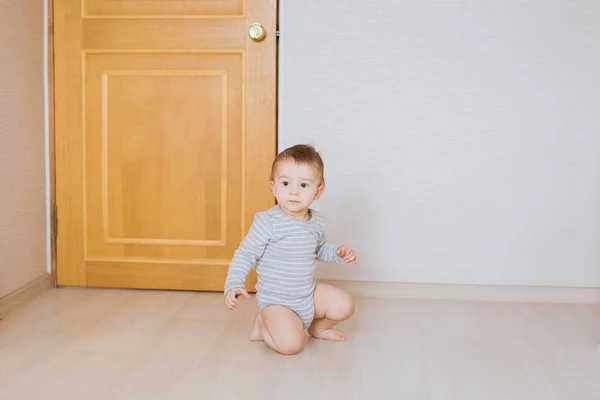 Bébé garçon mignon tout-petit assis sur le sol dans la chambre — Photo