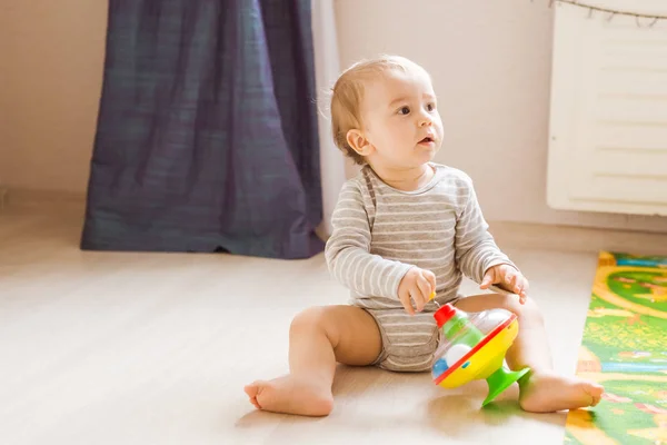 Söt baby pojke småbarn leker med leksak inomhus — Stockfoto