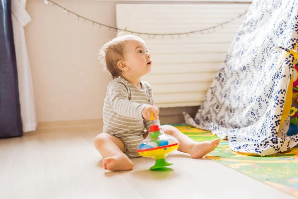 Söt baby pojke småbarn leker med leksak inomhus — Stockfoto