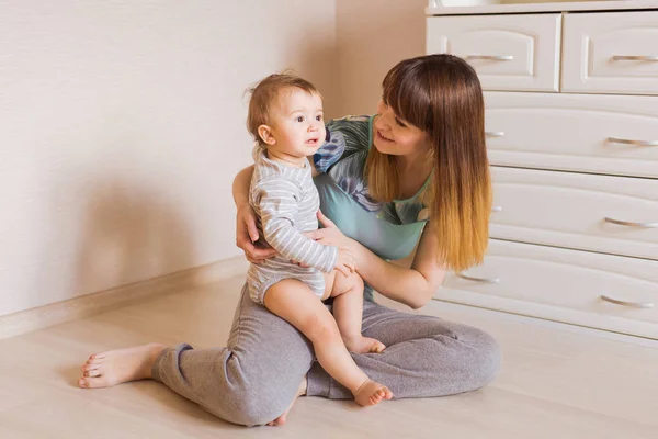 Feliz madre con adorable bebé niño en el interior — Foto de Stock