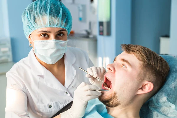Dentist doing a dental treatment on a patient close-up — Stock Photo, Image