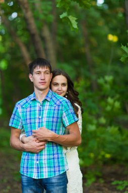 Genç bir romantik çift doğa üzerinde birbirlerine kucaklayan portresi