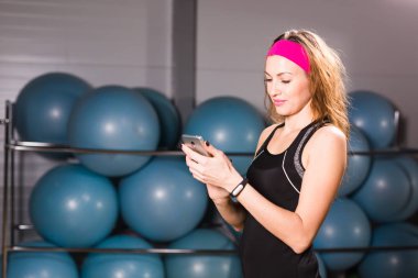 Genç kadın fitness izci ve smartphone içinde jimnastik salonu ile