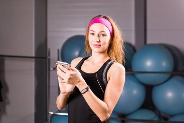 Genç kadın fitness izci ve smartphone içinde jimnastik salonu ile