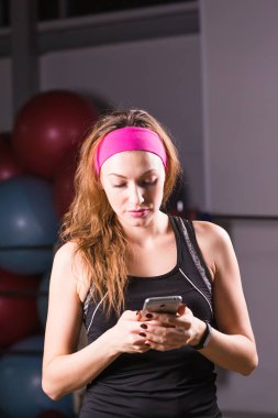 Genç kadın fitness izci ve smartphone içinde jimnastik salonu ile