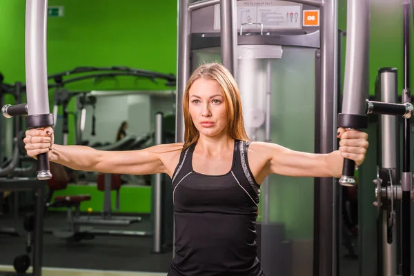 Hermosa mujer en forma muscular ejercitando los músculos de construcción — Foto de Stock