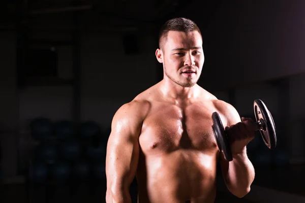 Portrait of strong healthy handsome Athletic Man Fitness Model posing with a dumbbell. — Stock Photo, Image