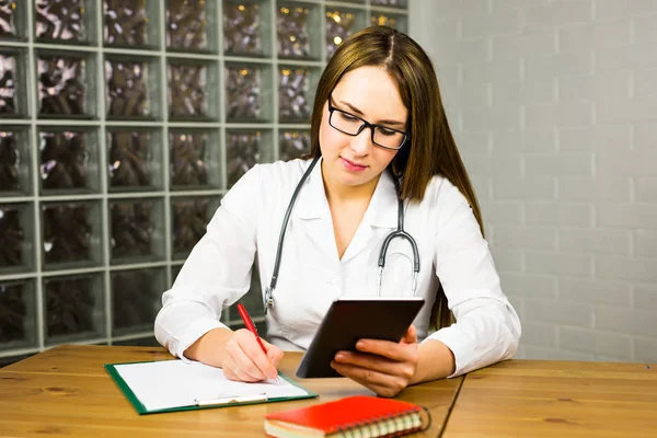 디지털 태블릿 의사입니다. 디지털 태블릿에 백색 실험실 외 투에서 매력적인 젊은 여성 의사. — 스톡 사진