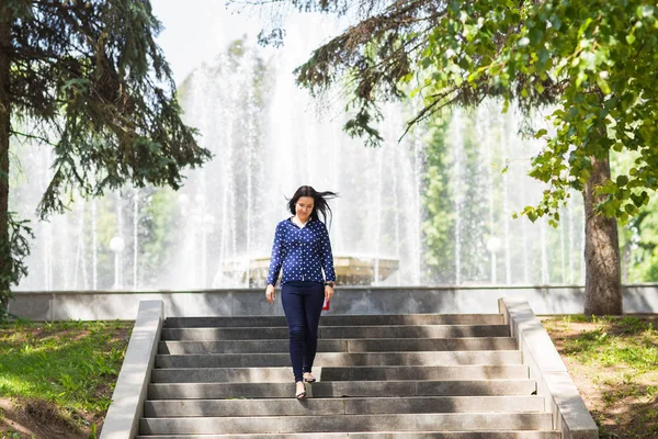Schöne junge Frau zu Fuß in grünen Sommerpark — Stockfoto