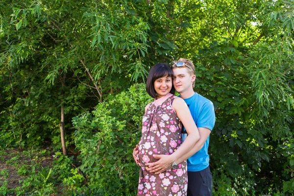 Feliz embarazada y su marido en el parque . — Foto de Stock