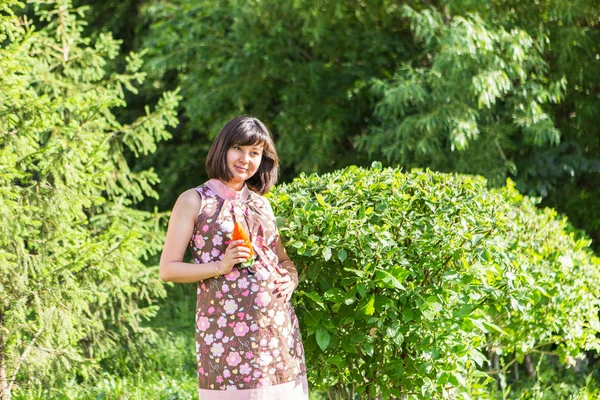 Беременная женщина позирует в летнем парке — стоковое фото