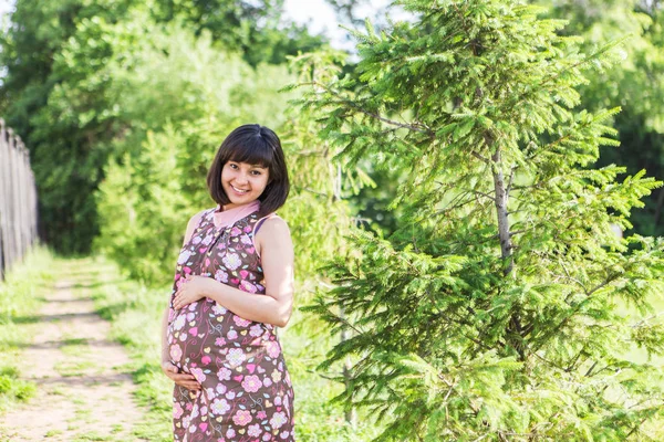 Mulher grávida posando no parque de verão — Fotografia de Stock