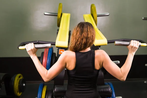 Szexi fitness lány, gyakorlása, fitness edzőteremben. Hogy a testmozgás, a sport szimulátor. — Stock Fotó