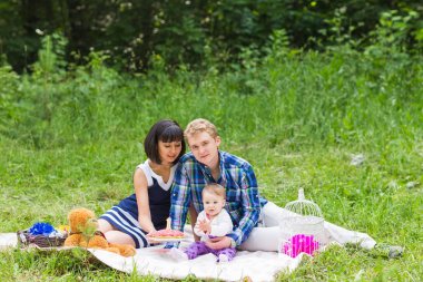 piknik ve parkta oynarken mutlu karışık ırk aile