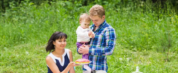 Familia de raza mixta feliz teniendo un picnic y jugando en el parque — Foto de Stock
