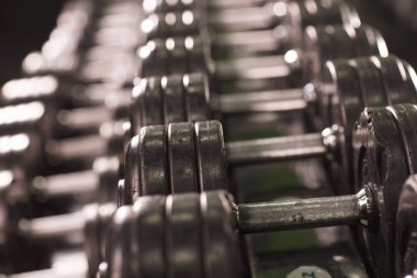 Spor salonundaki dambıllar yakın plan.