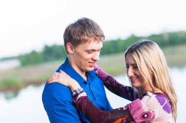 Göl kenarında kucaklayan aşık güzel genç çift portresi.