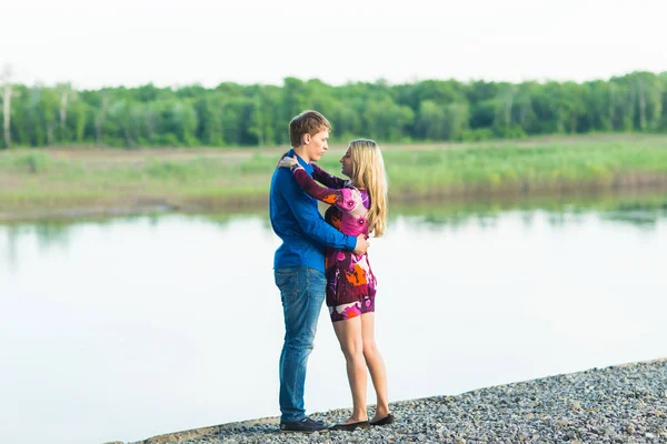 Vackra unga par i kärlek omfamna nära sjön. — Stockfoto