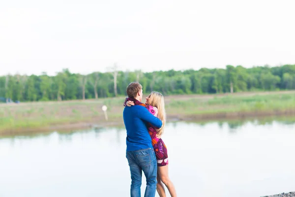 Hermosa joven pareja enamorada abrazando cerca del lago . — Foto de Stock