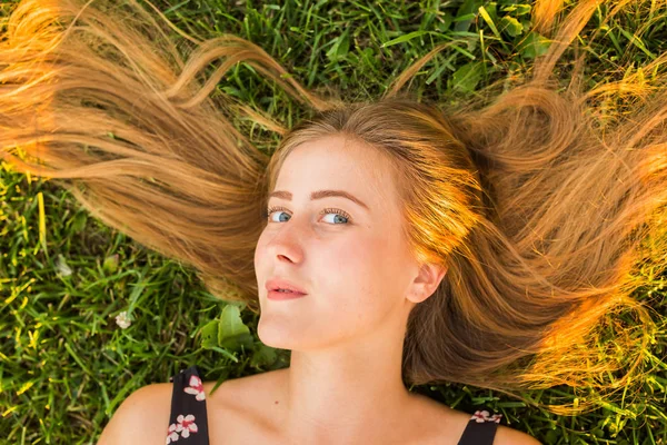 Portrait of a young woman lying on the grass — Stock Photo, Image