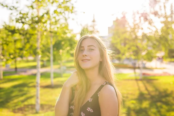 Zomer meisje portret. Gelukkige vrouw die lacht op zonnige zomer of lente buiten in het park. Mooie Kaukasische vrouw buitenshuis — Stockfoto