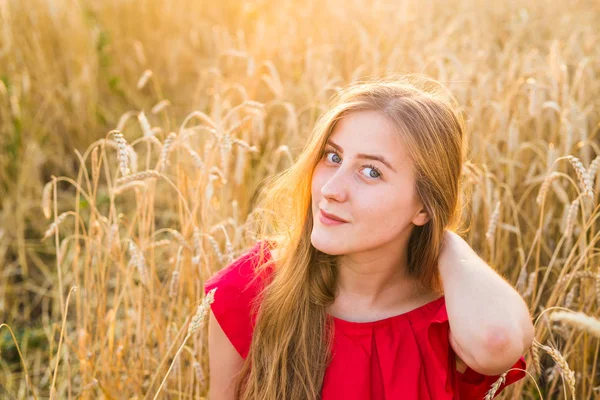 Hermosa joven en el campo de trigo al atardecer — Foto de Stock