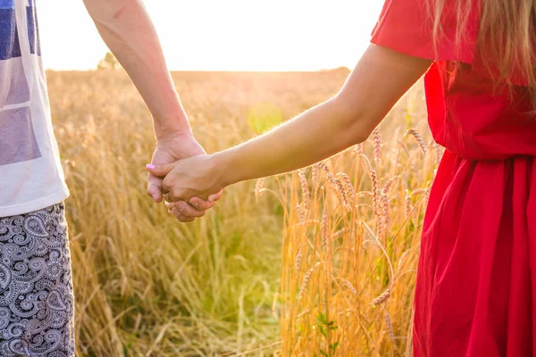 Nahaufnahme eines glücklichen jungen Paares, das auf einem Weizenfeld spaziert — Stockfoto