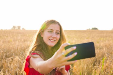 Mutlu kadın alanında cep telefonu ile selfie resim çekerken gülümseyen