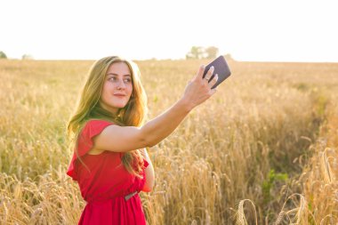 teknoloji, tahıl alan Smartphone'da tarafından kırmızı elbise alma selfie genç kadın gülümseyerek yaz tatil, tatil ve insanlar kavramı-
