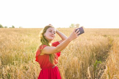 Mutlu kadın alanında cep telefonu ile selfie resim çekerken gülümseyen