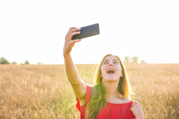 Teknoloji, tahıl alan Smartphone'da tarafından kırmızı elbise alma selfie genç kadın gülümseyerek yaz tatil, tatil ve insanlar kavramı- — Stok fotoğraf