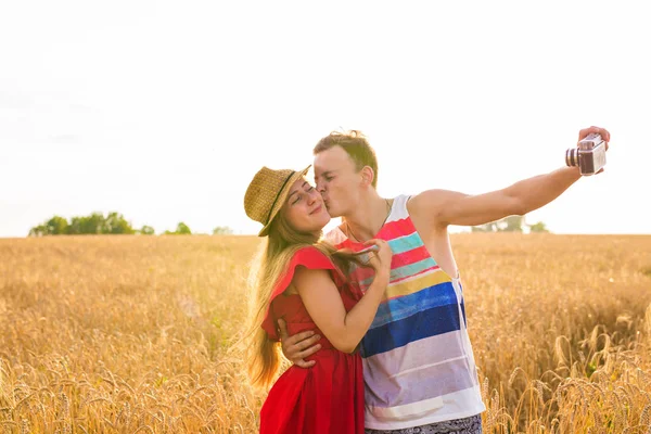 Junges glückliches Paar macht ein Selfie auf dem Feld — Stockfoto