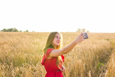 Mutlu kadın alanında cep telefonu ile selfie resim çekerken gülümseyen