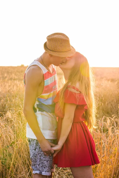 Casal elegante e moderno beijando no campo — Fotografia de Stock