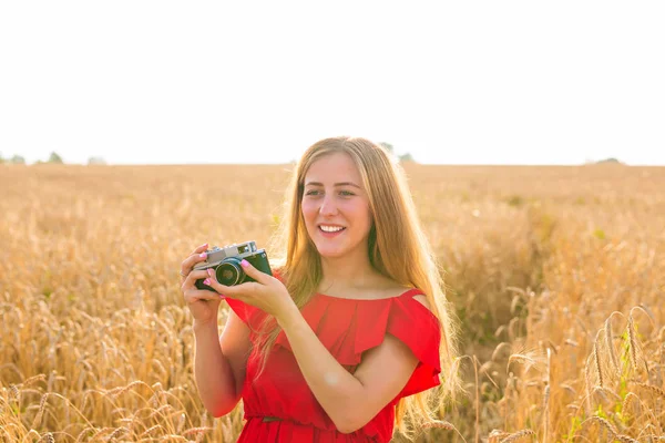 Retrato de una hermosa joven sonriente con cámara en el campo —  Fotos de Stock