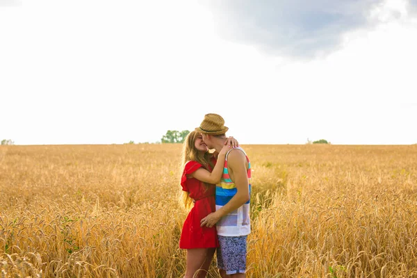 Jonge liefde paar zoenen op veld in het zonlicht — Stockfoto