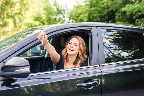 Schöne junge Fahrerin zeigt Autoschlüssel in der Hand — Stockfoto