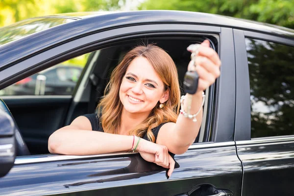 Schöne junge Fahrerin zeigt Autoschlüssel in der Hand — Stockfoto