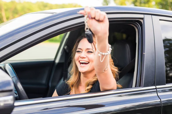 Schöne junge Fahrerin zeigt Autoschlüssel in der Hand — Stockfoto