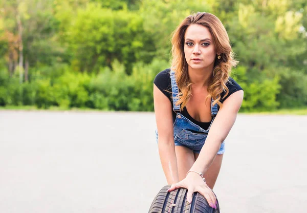 Sexy mulher mudando roda em uma beira da estrada — Fotografia de Stock