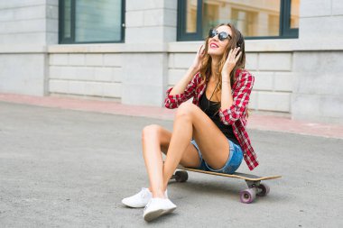 Kaykay üzerinde oturan güzel ve seksi kız