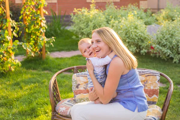 Lycklig harmonisk familj utomhus. mamma skrattar och leker med barnet på sommaren på naturen — Stockfoto
