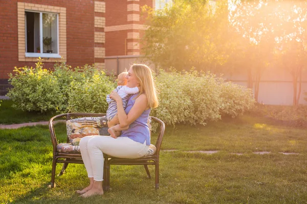 Glad mamma håller en ung son i parken. — Stockfoto