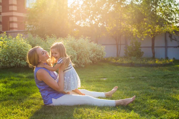 Gelukkige harmonieuze familie buitenshuis. moeder lachen en spelen met dochter meisje van de baby in de zomer op de natuur — Stockfoto