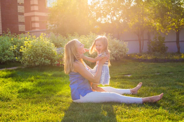 Gelukkige harmonieuze familie buitenshuis. moeder lachen en spelen met dochter meisje van de baby in de zomer op de natuur — Stockfoto