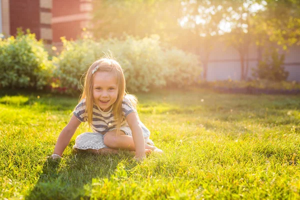 Niña feliz jugando en el prado en verano en la naturaleza —  Fotos de Stock